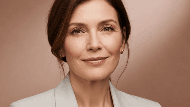 A middle-aged woman with short brown hair smiling confidently against a plain background.