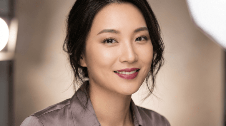 A close-up portrait of a smiling woman with natural, radiant skin, showcasing healthy complexion and soft, professional lighting.